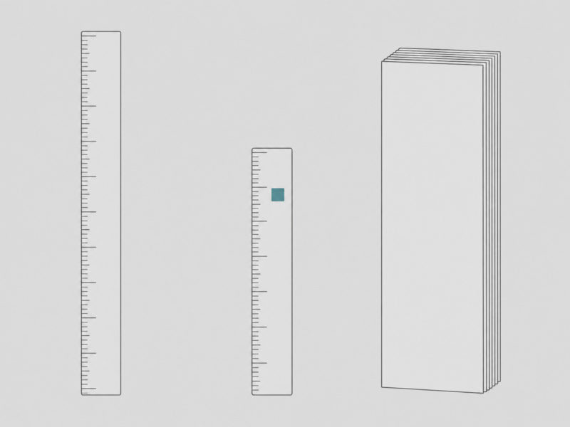 長さの違う2本のものさしが並んでいる。その横に、同じ大きさの書類の束が1つ